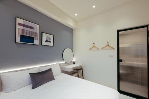 a bedroom with a white bed and a mirror at 參穗 SunSui B&B in Sanxing