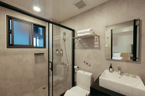 a bathroom with a shower and a toilet and a sink at 參穗 SunSui B&B in Dongshan