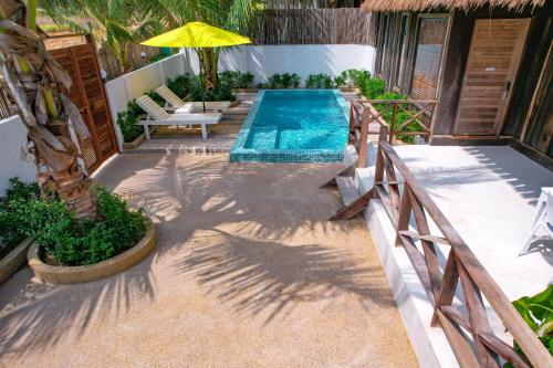 a swimming pool on a patio with an umbrella at One Beach Resort By EHM in Koh Rong Sanloem