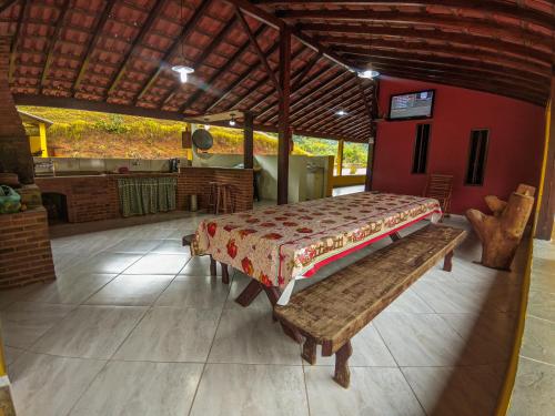 a bedroom with a bed and a bench in a room at Sítio Bosque das Palmeiras in Papucaia