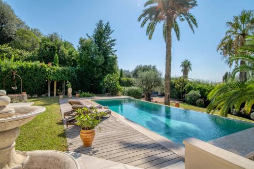 - une piscine dans une cour avec une terrasse en bois dans l'établissement Cannes Luxury Rental - Stunning 5 bedroom villa to rent, à Cannes