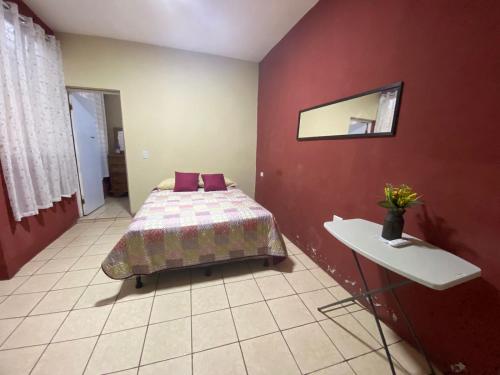 Schlafzimmer mit einem Bett und einem Wandspiegel in der Unterkunft Habitación Privada Andrea, en la Isla in Flores
