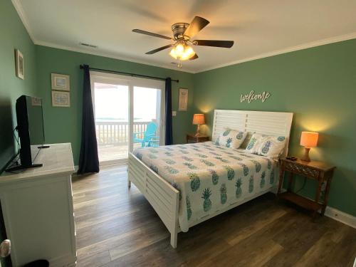 1 dormitorio con 1 cama y ventilador de techo en 2 if by Sea- East Unit en Emerald Isle