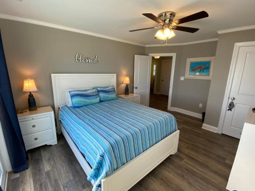 a bedroom with a bed and a ceiling fan at 2 if by Sea- East Unit in Emerald Isle