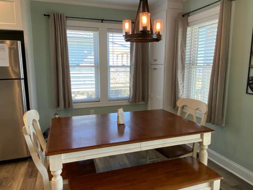 a kitchen with a wooden table and two chairs at 2 if by Sea- East Unit in Emerald Isle