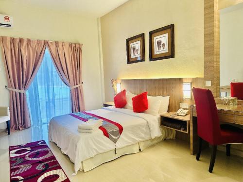 a hotel room with a bed and a desk and a desk at Rompin Beach Resorts in Kuala Rompin