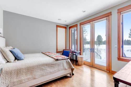 a bedroom with a bed and large windows at Meadowview Haven in Black Butte Ranch