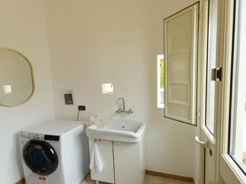 a white bathroom with a sink and a washing machine at Vacation home with private pool, Floridia in Floridia