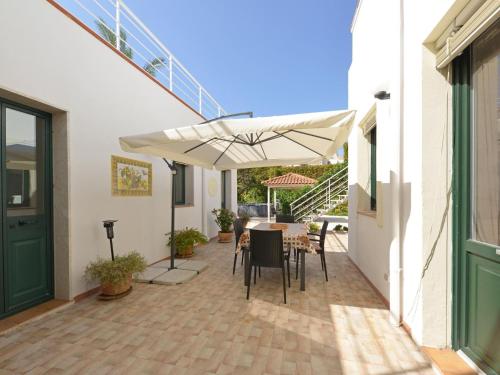 a patio with a table and a white umbrella at Vacation home with private pool, Floridia in Floridia