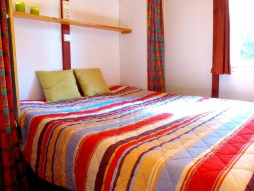 - une chambre avec un lit et une couverture colorée dans l'établissement Holiday Home in France near Atlantic Beach, à Moliets-et-Maa