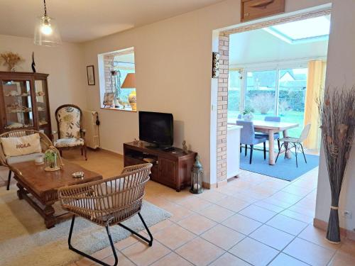 un salon avec une télévision, une table et des chaises dans l'établissement Holiday Home in St Marguerite near Sandy Beach, à Landéda