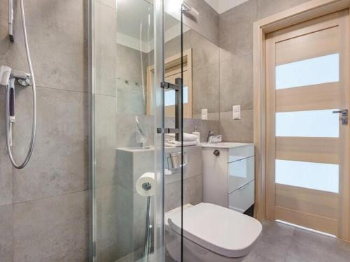 a bathroom with a toilet and a glass shower at 2-level apartment, pool, Pobierowo in Pobierowo