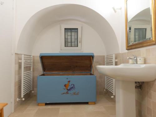 La salle de bains est pourvue d'un lavabo, de toilettes et d'un miroir. dans l'établissement Holiday home Trullo Tre Corbezzoli, Ostuni, à Ostuni