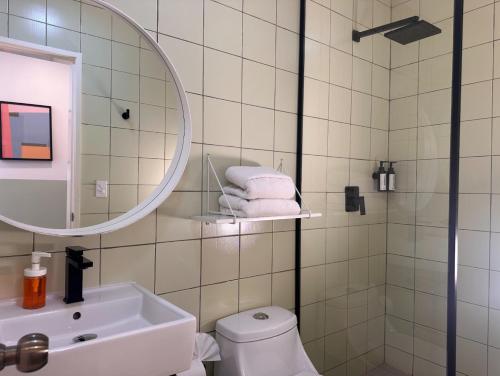 a bathroom with a sink and a mirror and a toilet at INTJ Hotel in Tijuana