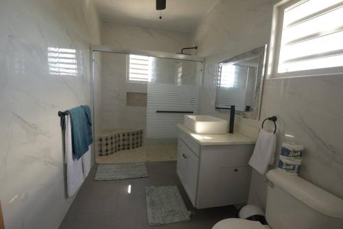 a white bathroom with a sink and a toilet at Sunset Seclusion. in The Valley