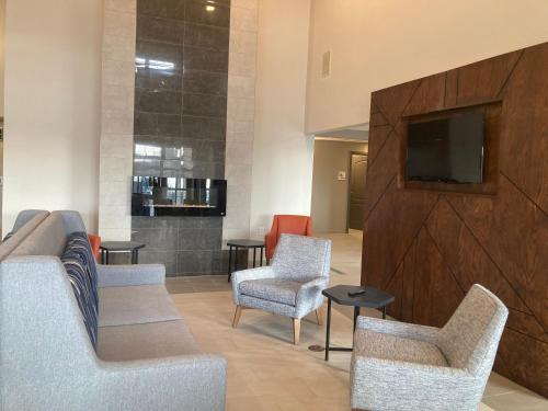 a lobby with chairs and a flat screen tv at Holiday Inn Express & Suites Port Washington by IHG in Port Washington