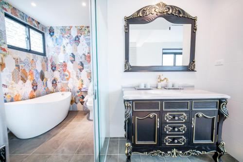 uma casa de banho com uma banheira, um lavatório e um espelho. em Penghu I Stay II em Magong