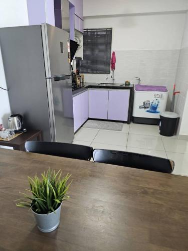 a kitchen with a wooden table and a refrigerator at A&H Homestay Seberang Jaya with Swimming Pool & 3 Bedroom AC in Permatang Janggus