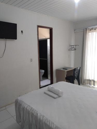 a bedroom with a bed and a desk and a mirror at HOTEL NOVAES in Castanhal