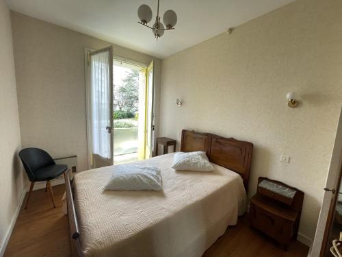 une chambre avec un lit avec une chaise et une fenêtre dans l'établissement Maison F6 en centre-ville de Royan, à 150m de la plage, avec garage et jardin - FR-1-71-55, à Royan