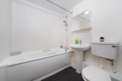 ロンドンにあるBeautiful 1 Bed Apartment with Living Roomの白いバスルーム(シンク、バスタブ、トイレ付)