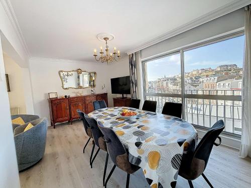 une salle à manger avec une table et des chaises et une grande fenêtre dans l'établissement Appartement au centre de Granville avec garage privatif et Wi-Fi gratuite - FR-1-361-510, à Granville