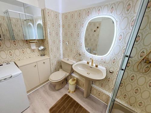 une salle de bain avec un lavabo, des toilettes et un miroir dans l'établissement Appartement au centre de Granville avec garage privatif et Wi-Fi gratuite - FR-1-361-510, à Granville