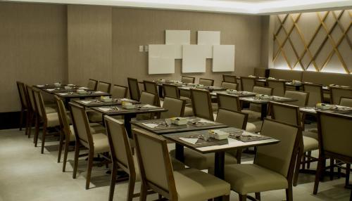 a dining room with long tables and chairs and a chandelier at Américas Copacabana Hotel in Rio de Janeiro