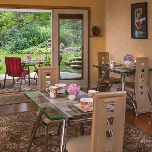 a dining room with tables and chairs and a patio at Cherry Valley Manor in Stroudsburg