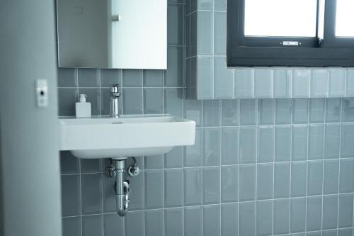 a bathroom with a white sink and a mirror at Norden Ruder Hostel Taitung Branch 2 in Taitung City