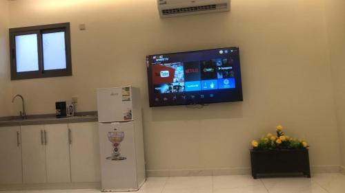 einen Flachbild-TV an der Wand einer Küche in der Unterkunft شقة فاخرة مودرن in Al Kharj