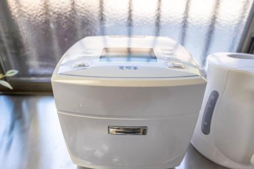a close up of a white hair dryer next to a window at Rokuan in Kikugawa
