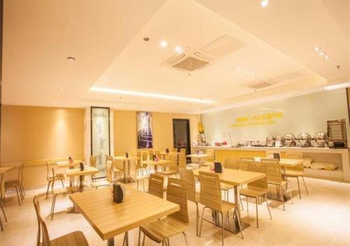 un restaurante con mesas y sillas de madera y una barra en City Comfort Inn Nanning Chaoyang Parkson Pedestrian Street, en Nanning