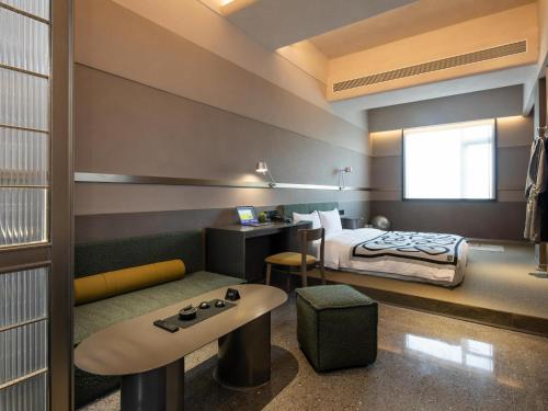 a hotel room with a bed and a desk at NOA Hotel SHENZHEN LUOHU in Shenzhen