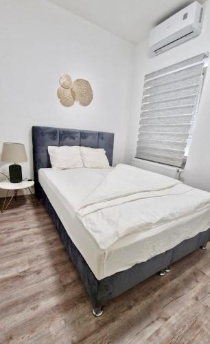 Ljubljana Central Cozy Apartment w Free Parking في ليوبليانا: غرفة نوم بسرير كبير مع شراشف بيضاء