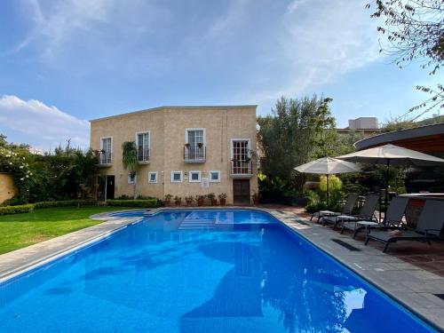 a large swimming pool in front of a house at Hotel Boutique La Granja in Tequisquiapan