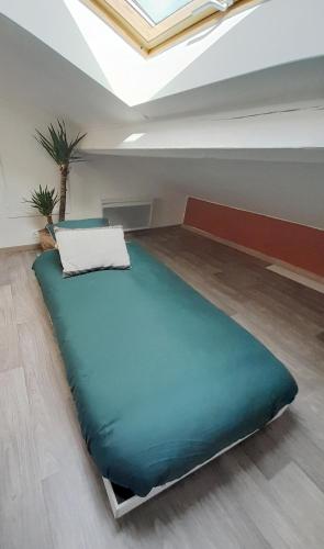 a large bed in a room with a ceiling at La Barbotine - Cosy - Centre ville in Bourg-en-Bresse
