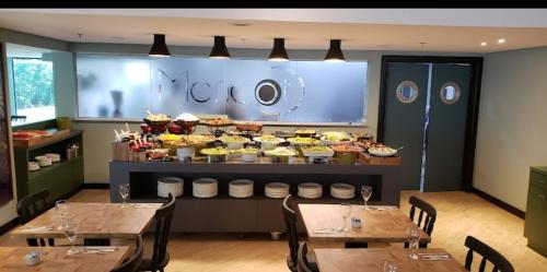 un restaurante con mesas y un buffet de comida en WYND BERRINI SP, en São Paulo