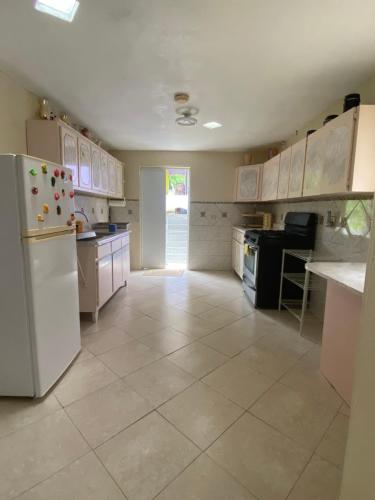 una cucina con frigorifero bianco e pavimento piastrellato di Apartamentovistadelrio2 a Orocovis