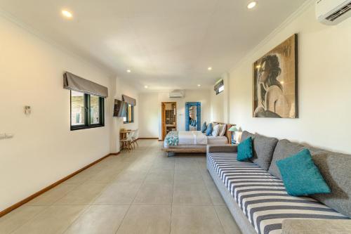 a living room with a couch and a bed at Komodo Suites Downtown in Labuan Bajo