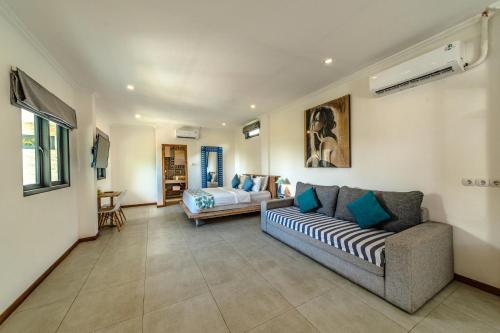 a living room with a couch and a bed at Komodo Suites Downtown in Labuan Bajo