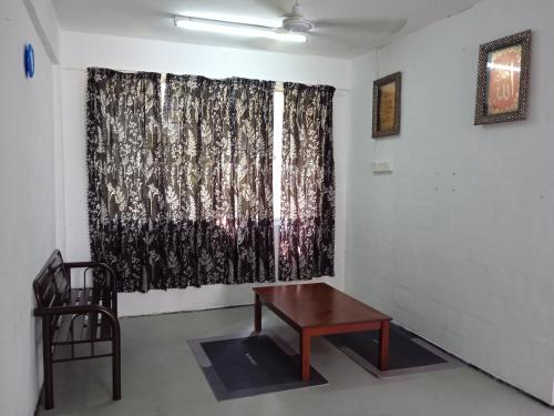 una camera con tavolo e finestra con tenda di Homestay Indrawasih a Perai