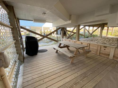 a wooden deck with a picnic bench on it at 2 if by Sea- East Unit in Emerald Isle