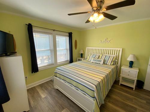 a bedroom with a bed and a ceiling fan at 2 if by Sea- East Unit in Emerald Isle