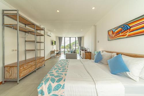 a bedroom with a large white bed and a large window at Komodo Suites Downtown in Labuan Bajo