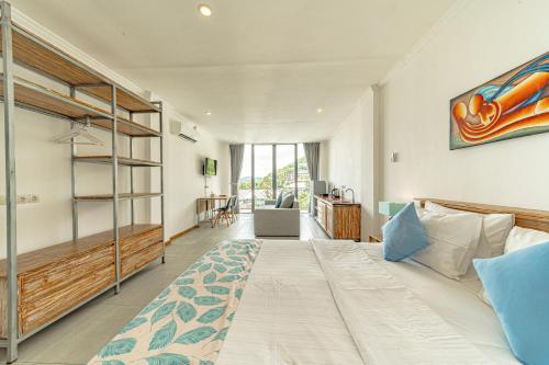 a bedroom with a large bed and a desk at Komodo Suites Downtown in Labuan Bajo
