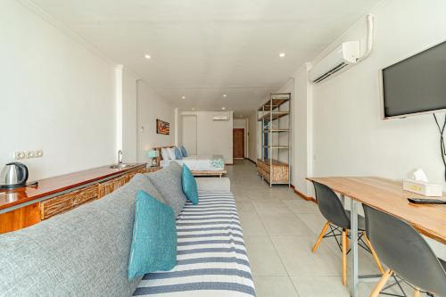 a living room with a couch and a television at Komodo Suites Downtown in Labuan Bajo