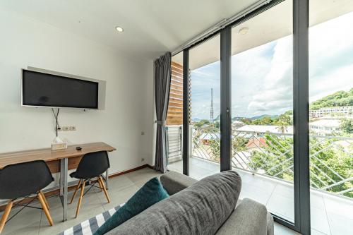 a living room with a couch and a desk and a tv at Komodo Suites Downtown in Labuan Bajo