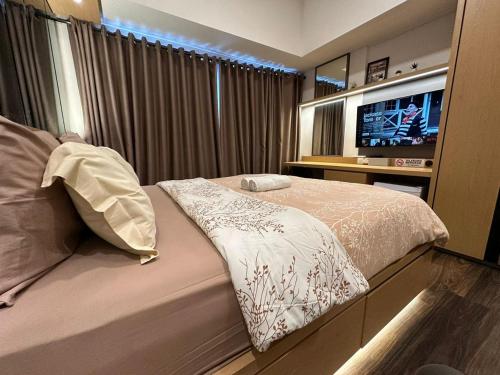 a bedroom with a bed and a flat screen tv at LUXURY CASA DE PARCO Apartment Near AEON MALL, THE BREEZE, ICE BSD in Tangerang