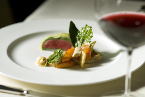 a white plate with food and a glass of wine at Landhaus Eggert in Münster